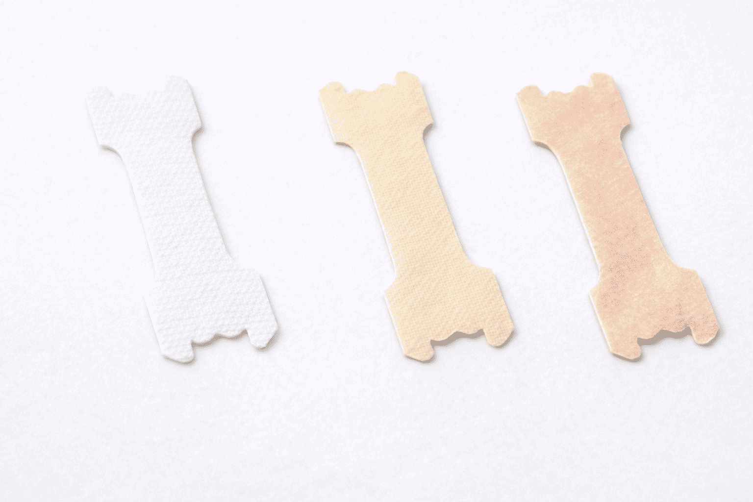 Flat lay of non-woven, cotton, and silk medical fabrics arranged side by side